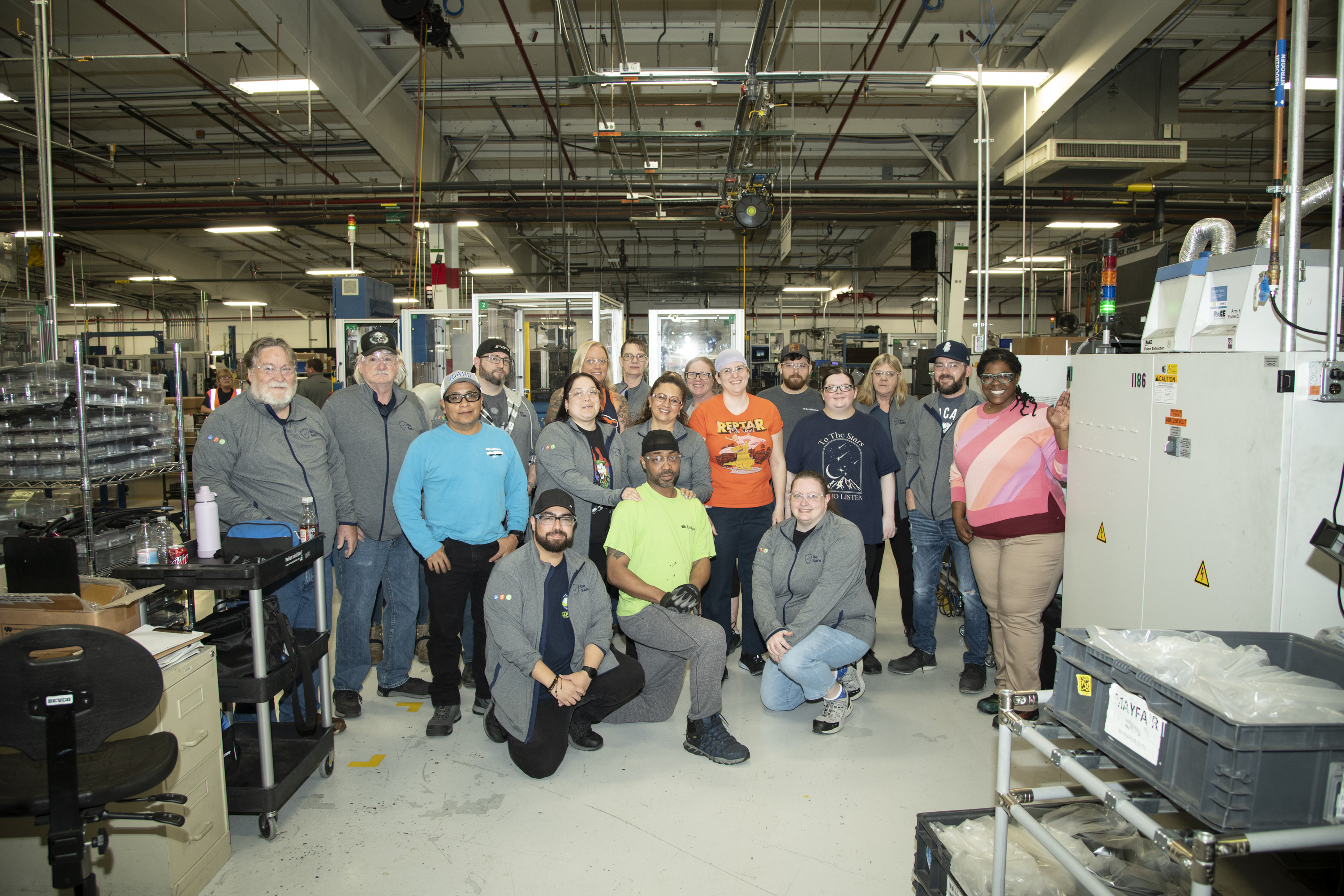 Group of people pose in manufacturing plant