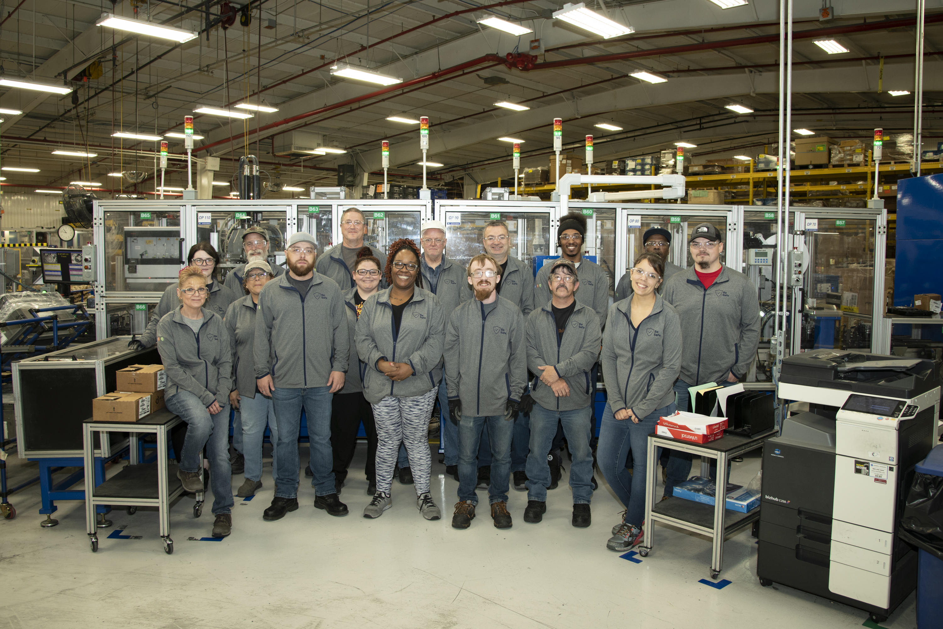 Group of people pose in manufacturing area